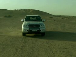 Vehicle driving in Wadi Araba desert to camera, Jordan Stock Footage