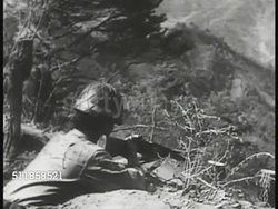 1950: KOREAN CONFLICT (WAR): Tank moving over & down hill, believed to be Russian T-34. Artillery firing. BEHIND South Korean (Republic of Korea) soldier firing rifle hilltop. UN Forces & US soldiers riding in transport trucks on road. The Cold War Instructional Video