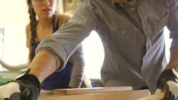 Young Caucasian man cuts board with table saw in workshop Stock Footage