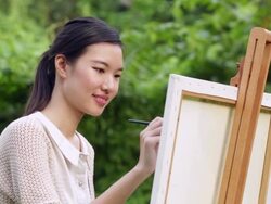 CU Woman painting on an easel in nature. Stock Footage