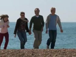 MS, PAN, Family with two children (10-11, 12-13) walking on Brighton beach, Brighton, Sussex, United Kingdom Stock Footage