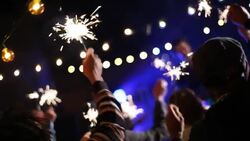 Rack focus from audience sparklers to lead singer at concert Stock Footage