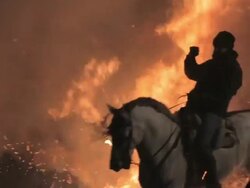 L/S Horses and riders crossing big flames Stock Footage