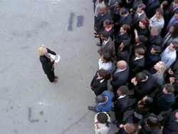 High angle wide shot woman with bullhorn shouting at crowd of businesspeople / crowd stepping back Stock Footage
