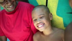 Father talks with boys leaning on graffitied wall in Rio de Janeiro Stock Footage