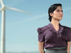 Young woman by a wind turbine Stock Footage
