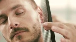 Barber cut a client's beard with clippers Stock Footage