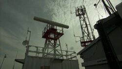 A radar antenna spins atop a tower. Stock Footage