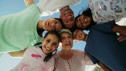 Multi-generation family huddling and circling over camera Stock Footage