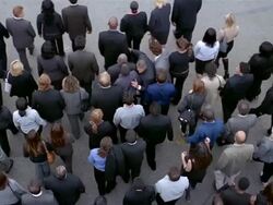 Slow motion high angle wide shot overhead view of man fighting his way through crowd of businesspeople Stock Footage