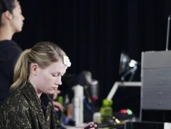 MS PAN Fashion models backstage at fashion show make-up artist and hair-stylist prepping models Stock Footage