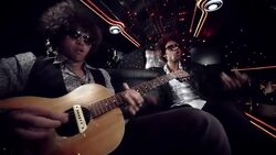 Hip-hop artist sings and dances while rocker jams on acoustic guitar in limousine at awards show Stock Footage