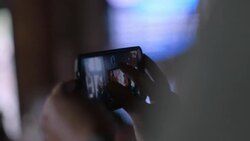 Man zooms in with smartphone camera and snaps photo of band at rock concert Stock Footage