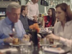 MS R/F Men and women talking in restaurant, waiter serving food Stock Footage