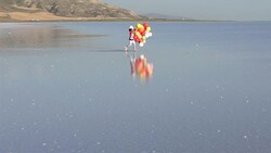 Middle Eastern little girls walking on the water with color balloons - SLOW MOTION Stock Footage