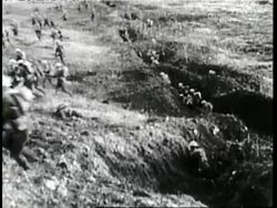 Soldiers shoot from trenches and then run across a battlefield during World War I. News Clip