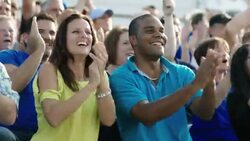Spectators cheer and high-five at a sporting event. Stock Footage