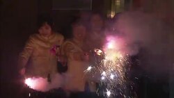 Celebrants wave lighted fireworks and sparklers on the street for Chinese New Year. Stock Footage
