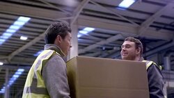 Workers carrying cardboard box in distribution warehouse Stock Footage