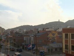 Residential area with shop, busy road and views of built up areas on hills in b/g, Cochabamba, Bolivia Stock Footage