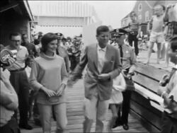 B/W 1961 John + Jacqueline Kennedy walking on pier greeting people / Hyannis Port Stock Footage