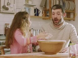 CU Shot of Daddy & daughter making mess while sieving flour in kitchen / London, United Kingdom  Stock Footage