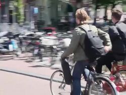 WS PAN Two cyclists moving on canal bridge / Amsterdam, The Netherlands, Holland Stock Footage