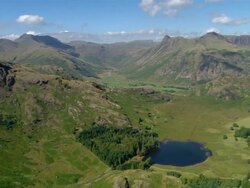 Aerial view of Blea Tarn in the Lake District / Langdale Pikes in background / Cumbria, England Stock Footage