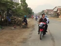 MS POV SLO MO Travelling 2 boys on red scooter laughing and talking / Road from Luang Prabang to Nong Khio, Luang Prabang, Laos Stock Footage