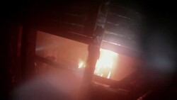 Slow Motion firefighter POV looking into burning room, firefighter sprays it with hose Stock Footage