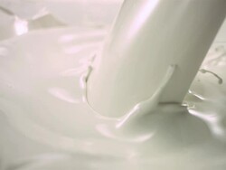 CU SLO MO Milk pouring while blocks of chocolate falling into milk Stock Footage