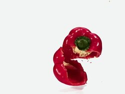 MS SLO MO Red capsicum falling and breaking on floor against white background / Vieux Pont, Normandy, France  Stock Footage