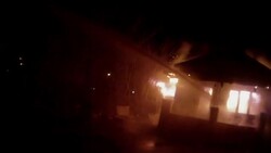 Slow Motion firefighter POV watching water spray burning home, extinguishes fire Stock Footage