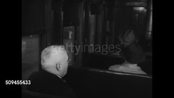 1920: U.S. TRAIN RIDE: PASSENGERS: WS Steam train taking turn. DRAMATIZATION: INT MS Male passenger asking conductor arrival time (SOT). EXT LA MS Passenger in between car platform getting hat blown by wind. INT MS Conductor entering passenger car. Instructional Video