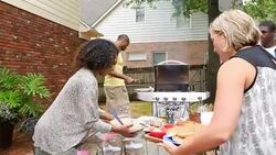 MS TS Group of friends carrying food to table during outdoor dinner party on summer evening Stock Footage
