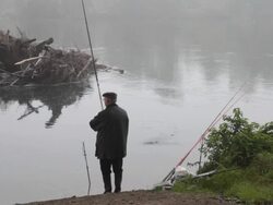 Fisherman on river side in autumn Stock Footage