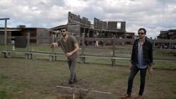 Young man tosses horseshoe, cheers, and high fives friend Stock Footage
