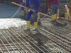 Workers Directing Concrete Onto The Construction Site Stock Footage