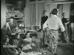 MOT 1947: PARIS, FRANCE: FRENCH FASHION: *TU 'Pierre Balmain' sign on building. VS Designer Pierre Balmain (1914-1982) w/ assistants accessorizing gown jacket on model, holding flower cluster, drawing sketch, wrapping rope of flowers off-shoulder Instructional Video