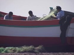 "Men preparing nets on colourful wooden boat sitting on sandy beach, Trujillo, Peru [PerÃƒÂº]" Stock Footage