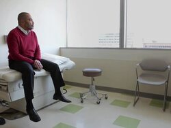 MS Mature male patient sitting on exam table in clinic room/Seattle, Washington, USA Stock Footage