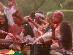 Family celebrating holi festival in the lawn  Stock Footage