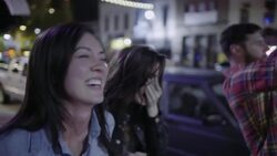 Guy picks up traffic cone and holds it up like a megaphone to make friends laugh in downtown Austin, Texas at night Stock Footage