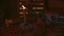 A candle flickers on a table near an open journal. Stock Footage