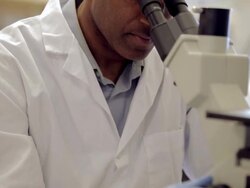 MS TU Male laboratory technician looking into microscope at Cancer research Healthcare medicine  Industry DNA sequencing Laboratory / Vancouver, BC, Canada    Stock Footage
