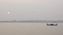 Fisherman return to the banks of the River Jamuna Bangladesh at sunset to unload sell auction and share their catch of small fish before tending to nets and returning home Stock Footage