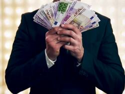 Man with money in front of lightwall Stock Footage