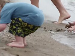 MS Little girl playing with sand on beach at water break and little boy picking up stones on beach / Toronto, Ontario, Canada Stock Footage