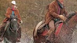 SLO MO TD Herdsmen crossing river on horses Stock Footage