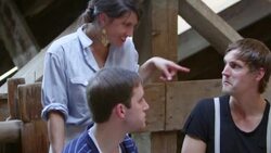 MS TU Woman in discussion with friends at dining table in rustic building Stock Footage